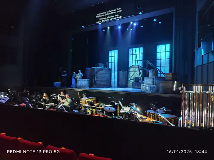 A surtitle bar above the stage, two languages.