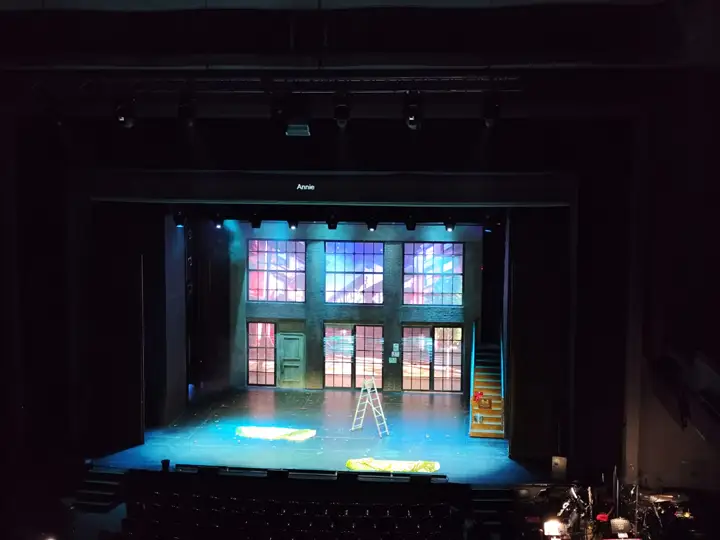 A stage before the house comes in, the surtitle line above.