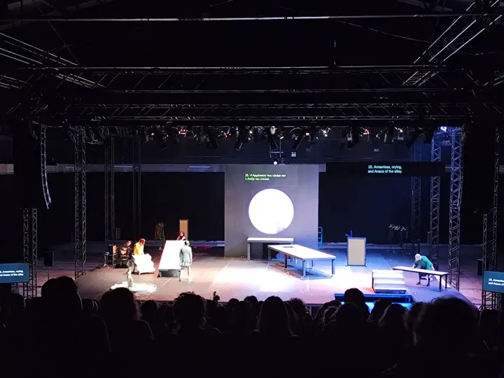 Titles on screens at the sides of the stage.